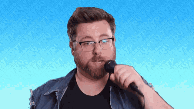 a man singing into a microphone with a blue background