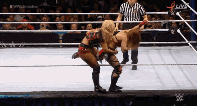 two women are wrestling in a wrestling ring with the words wwe evolution on the bottom right