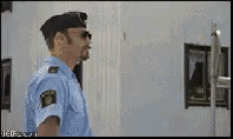 a man in a police uniform is standing in front of a white building .