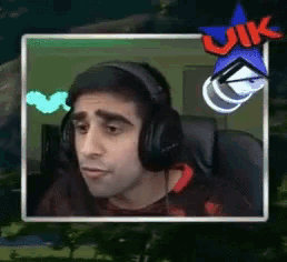 a man wearing headphones is sitting in front of a screen that says uk on it