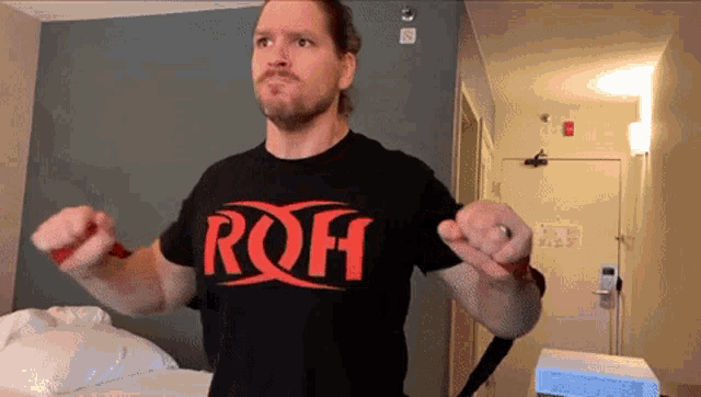 a man wearing a black t-shirt that says roh on it
