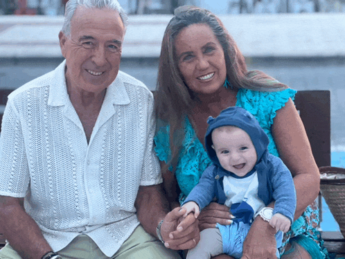 a man and woman holding a baby in their lap
