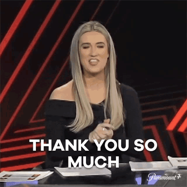 a woman is sitting at a table saying thank you so much .