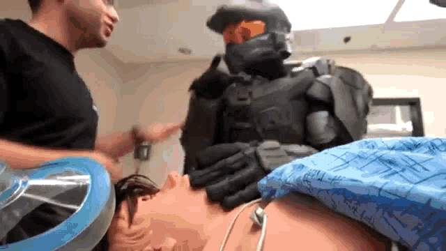 a man in a halo costume is talking to a man in a hospital gown