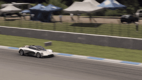 a white sports car is driving on a track