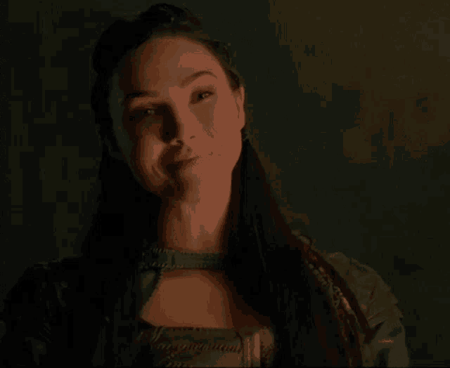 a close up of a woman 's face with a smile on her face in a dark room .