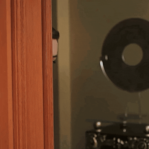 a woman peeking out from behind a door