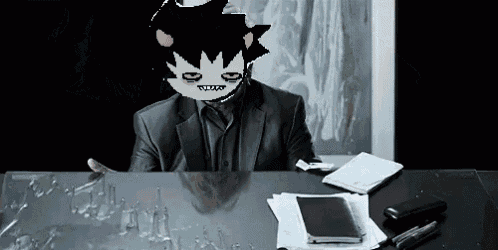 a man in a suit is sitting at a desk with a mask on his face