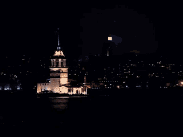 a boat in the water with a tower in the background and a city in the background