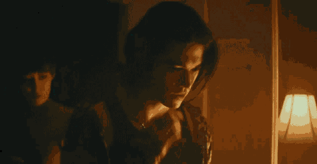a man with long hair is talking on his cell phone
