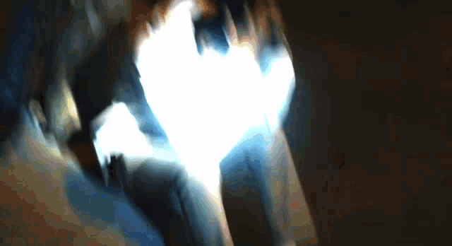 a blurry picture of a person walking in the dark with a light behind them
