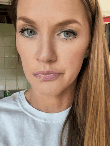 a close up of a woman 's face with long hair and blue eyes