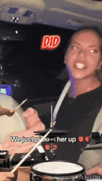 a woman playing drums with the words did we just pick her up