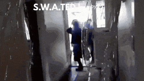 a s.w.a.t.f.i. officer stands in a hallway