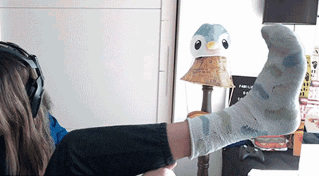 a person wearing a pair of socks with a penguin on top of a lampshade