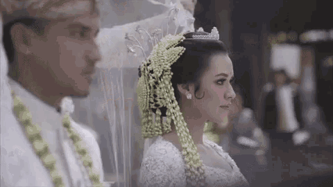 a bride and groom are standing next to each other at a wedding .
