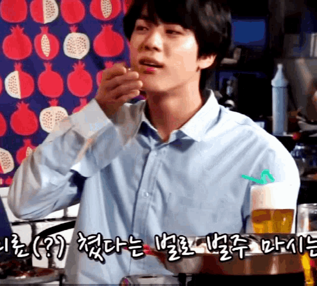 a man in a blue shirt is drinking from a straw