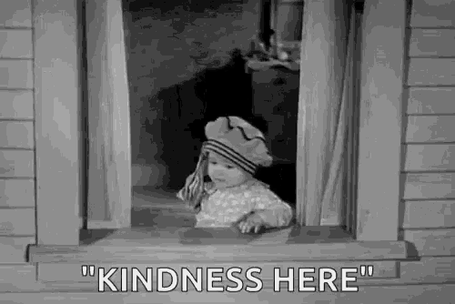 a baby is looking out of a window with the words `` kindness here '' .