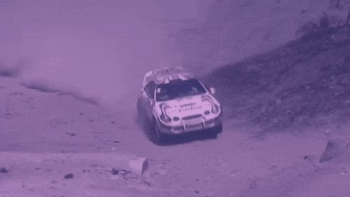 a white castrol rally car is driving on a dirt road