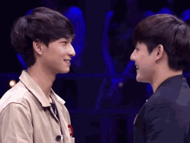 two young men are looking at each other with their eyes closed