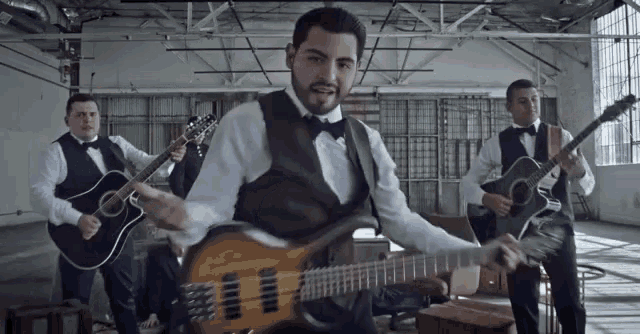 a group of men playing guitars in a room .