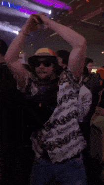 a man wearing a hat that says supreme is dancing in a crowd