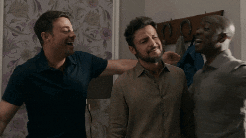 three men are standing next to each other and one has his arm around the other 's shoulder