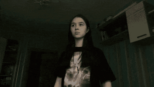 a girl with long hair is wearing a black t-shirt with a picture of a lightning bolt on it
