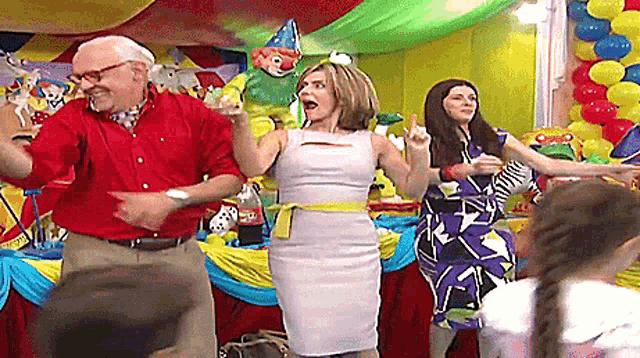 a woman in a white dress is dancing with a group of people