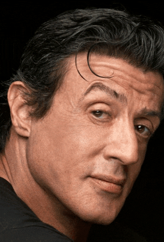 a close up of a man 's face with a dark background