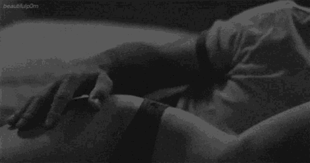 a black and white photo of a person holding another person 's arm .