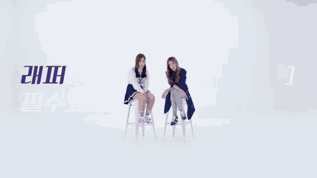 two women sitting on stools with purple letters that say ' eh ' on them