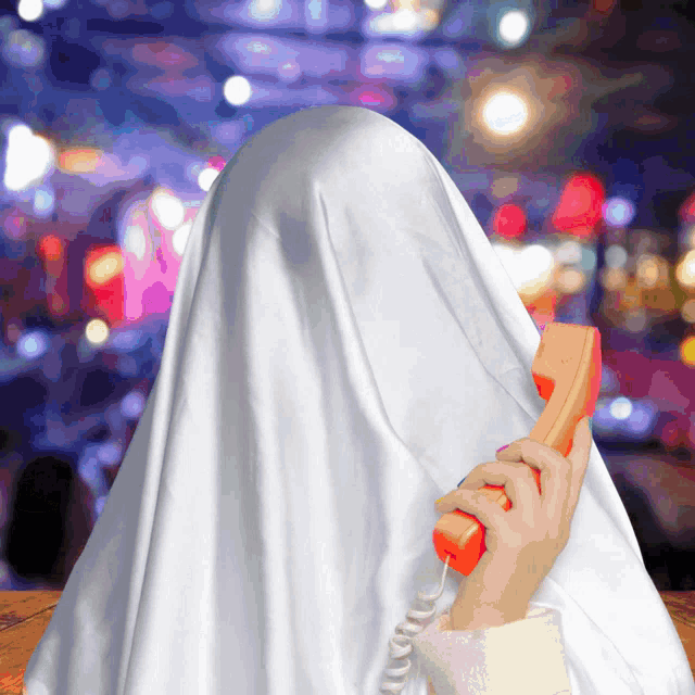a person covered in a white sheet is talking on an orange phone