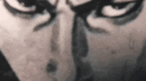 a close up of a man 's face with a beard and a beard .