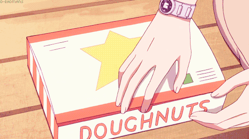 a box of doughnuts is being opened by a person