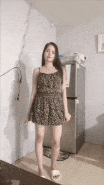 a woman in a leopard print dress is standing in front of a fridge