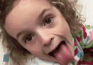 a little girl with curly hair is sticking her tongue out and making a funny face .