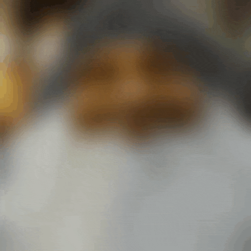 a blurred image of a person 's face with a white shirt on