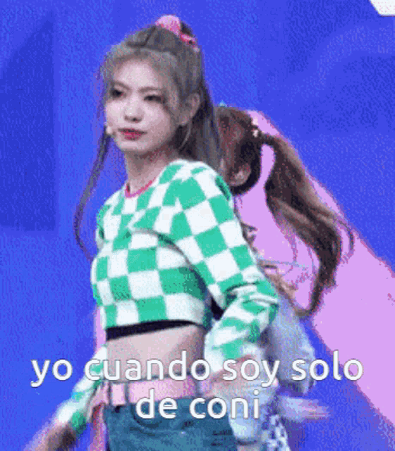 a girl in a green and white checkered shirt is standing on a stage .