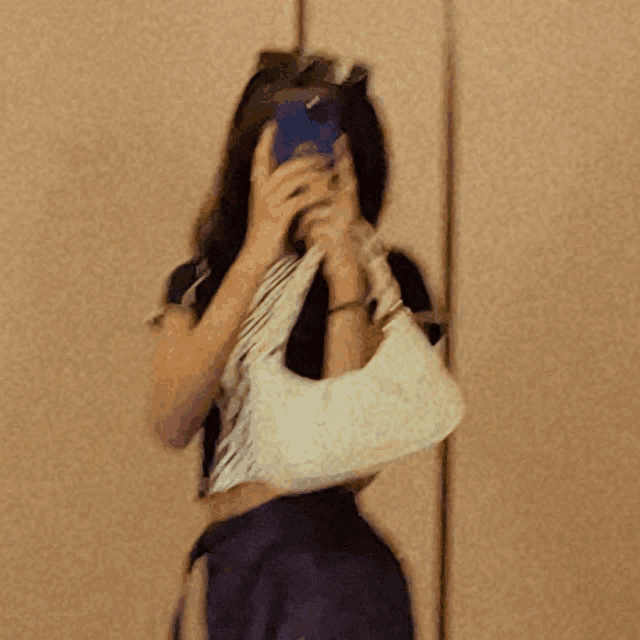 a blurry picture of a woman taking a selfie with her phone