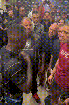 a man wearing a ufc shirt stands in a crowd