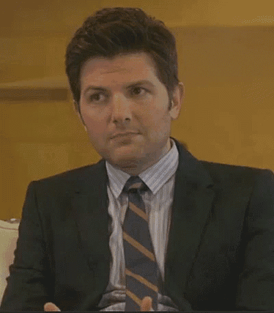 a man in a suit and tie is sitting on a couch