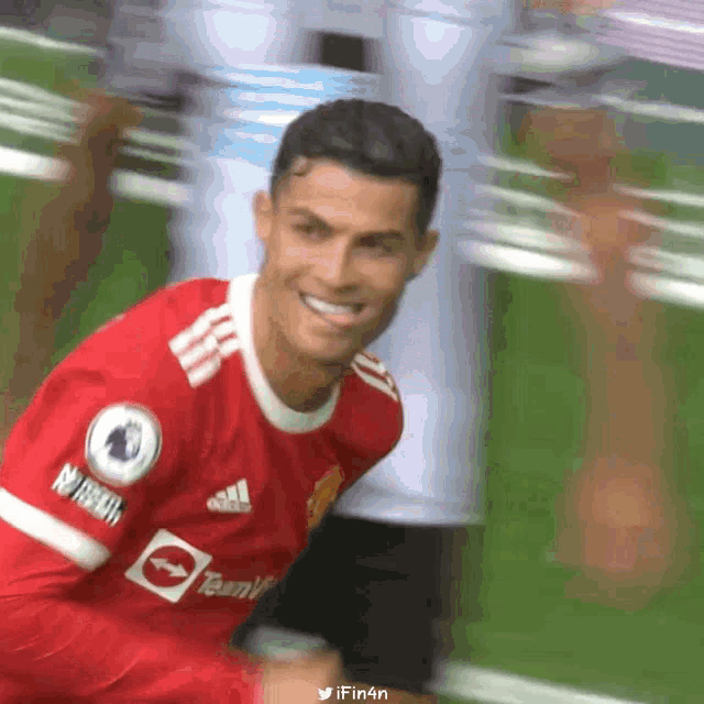 a soccer player in a red adidas jersey smiles for the camera