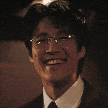 a close up of a man wearing glasses and a black suit