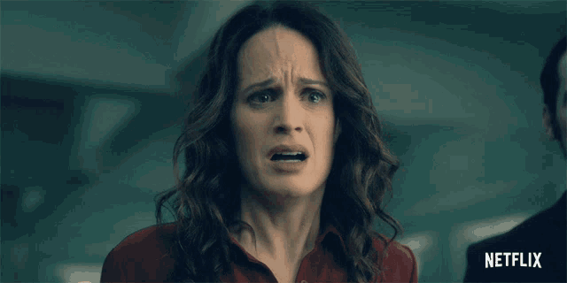 a woman in a red shirt with a netflix logo on the bottom right