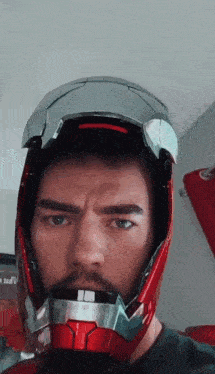 a man with a beard wearing a red and silver helmet