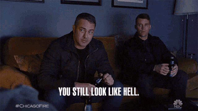 two men are sitting on a couch and one of them is saying you still look like hell