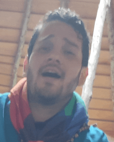 a man with a beard and a scarf around his neck looks at the camera
