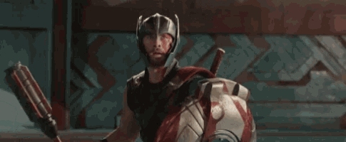 thor is wearing a helmet and holding a sword and shield and saying yes .