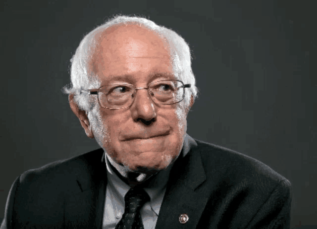 a man wearing glasses and a suit has a badge on his jacket that says ' congressman '